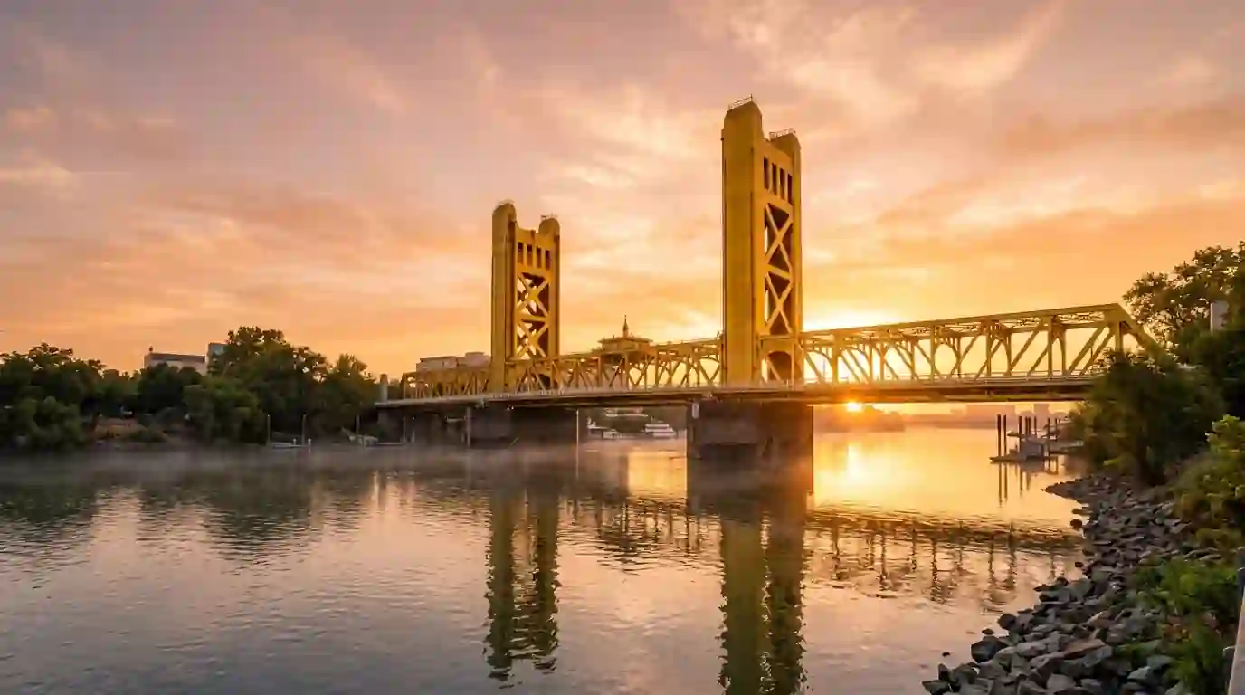 Sacramento Tower Bridge in gold paint at sunrise over the river